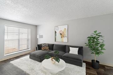 Denver apartment for rent - A living room with a grey couch, a white coffee table, and a painting on the wall.