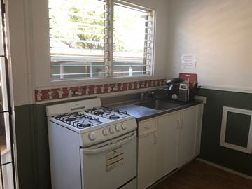 Honolulu apartment for rent - A white gas stove in a kitchen with green walls.