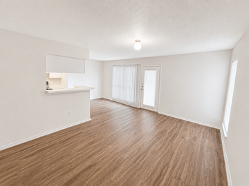 Houston apartment for rent - A room with wooden flooring and white walls.