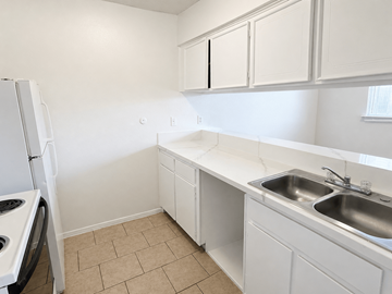 Pasadena apartment for rent - A kitchen with white cabinets and a tiled floor.