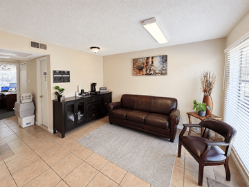 Houston apartment for rent - A living room with a brown leather couch and a brown leather chair.