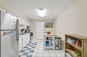 Tampa apartment for rent - A kitchen with a refrigerator, a table, and a bookshelf.