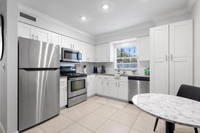 Tampa apartment for rent - a kitchen with white cabinets and stainless steel appliances