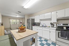 Tampa apartment for rent - A kitchen with white cabinets and a wooden island.