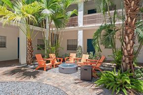 Tampa apartment for rent - a patio with a fire pit and chairs in front of a building