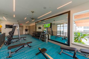 Fitness center with mirrors and turquoise flooring