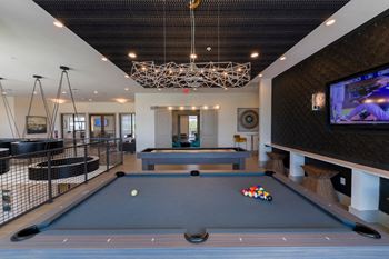 Recreation area with pool tables and geometric chandelier