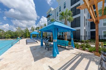 Pool deck with blue cabanas and lounge chairs