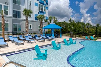 Swimming pool with turquoise in water lounge chairs