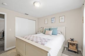 Tampa apartment for rent - A bedroom with a bed, pillows, and pictures on the wall.