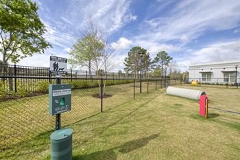 Fenced dog park with waste station and agility equipment