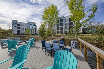 Waterfront deck with adirondack chairs and outdoor dining