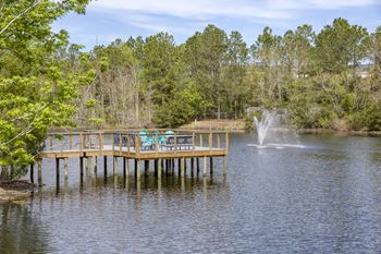 Lakeside fishing pier with fountain and seating