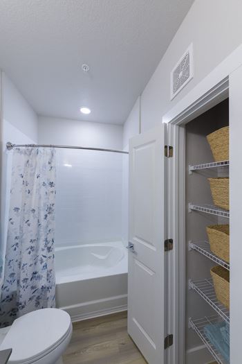 Bathroom with tub shower combo and linen closet