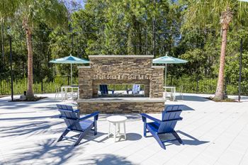 Outdoor fireplace seating area with blue chairs