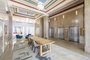 Jacksonville apartment for rent - A large wooden table is surrounded by chairs in a spacious room with a patterned carpet.