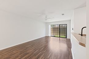Tampa apartment for rent - A room with a ceiling fan and a window with bars.