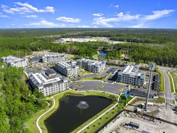 Aerial view of apartment community with central pond