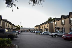 Tampa apartment for rent - A parking lot with cars and trucks in front of apartment buildings.