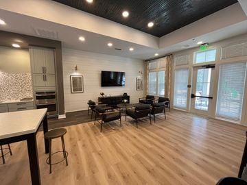 Tallahassee apartment for rent - a living room with a tv and a table and chairs