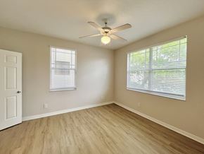 Tampa apartment for rent - A room with a ceiling fan and two windows with blinds.