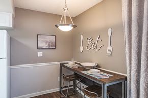 Plant City apartment for rent - A dining area with a table set for two and a framed picture on the wall.
