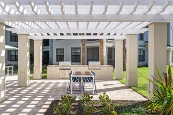 Outdoor grilling area with dining table and pergola