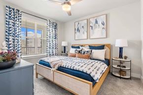 St. Johns apartment for rent - Bedroom with blue accent pillows and woven headboard at Longleaf at St. Johns Apartments, St. Johns, Florida