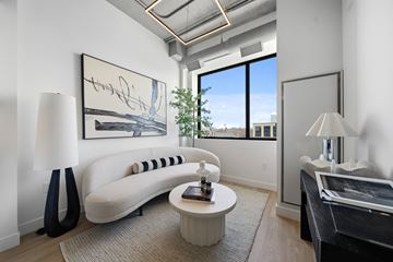 London apartment for rent - A living room with a white couch, a small table, and a painting on the wall.