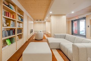 Madison apartment for rent - A living room with a white couch and a bookshelf filled with books.