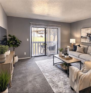 Kansas City apartment for rent - A living room with a grey carpet and a glass coffee table.