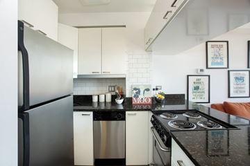 Chicago apartment for rent - A kitchen with a black counter top and white cabinets.