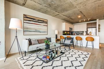Chicago apartment for rent - A modern living room with a glass coffee table and a large abstract painting on the wall.