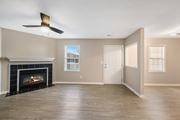 Greenville apartment for rent - A living room with a fireplace and a ceiling fan.
