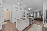 Raleigh apartment for rent - A modern kitchen with a large island and pendant lights.at Address East End, North Carolina