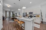 Raleigh apartment for rent - A kitchen with a white countertop and wooden bar stools.at Address East End, Raleigh, 27610