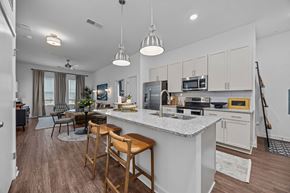 Raleigh apartment for rent - A kitchen with a white countertop and wooden bar stools.at Address East End, Raleigh, 27610