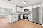 Creedmoor townhouse for rent - A kitchen with a refrigerator, oven, and microwave.