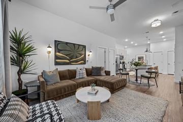 Raleigh apartment for rent - A living room with a brown couch, a coffee table, and a painting on the wall.
