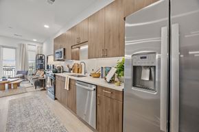 Charlotte townhouse for rent - A modern kitchen with a refrigerator on the right side.at Adler Montford Park + Drexel Townes, Charlotte, NC, 28209