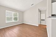 Creedmoor townhouse for rent - A room with wooden flooring and a window with blinds.