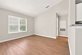 Creedmoor townhouse for rent - A room with wooden flooring and a window with blinds.
