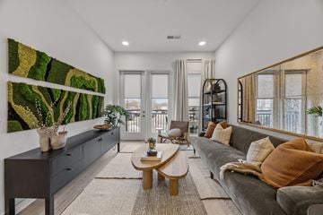 Charlotte townhouse for rent - A living room with a grey couch and a large painting on the wall.