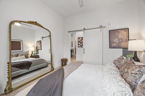 Charlotte townhouse for rent - A bedroom with a large bed and a large mirror.at Adler Montford Park + Drexel Townes, Charlotte, NC, 28209