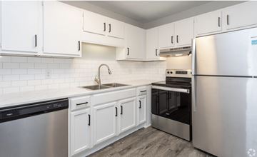 Greenville apartment for rent - A kitchen with white cabinets and stainless steel appliances.