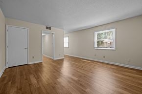 Raleigh triplex for rent - the living room and dining room of an empty house with wood flooring at Raleigh Rentals, North Carolina, 27604