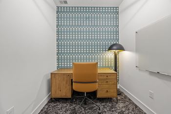 A room with a chair, a desk, and a lamp