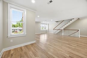 Charlotte townhouse for rent - A spacious room with wooden floors and a staircase.