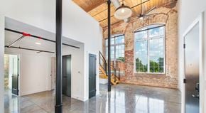 Greenville apartment for rent - A large open space with a brick wall and a staircase.