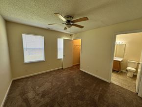 New Bern apartment for rent - an empty living room with a ceiling fan and a bathroom